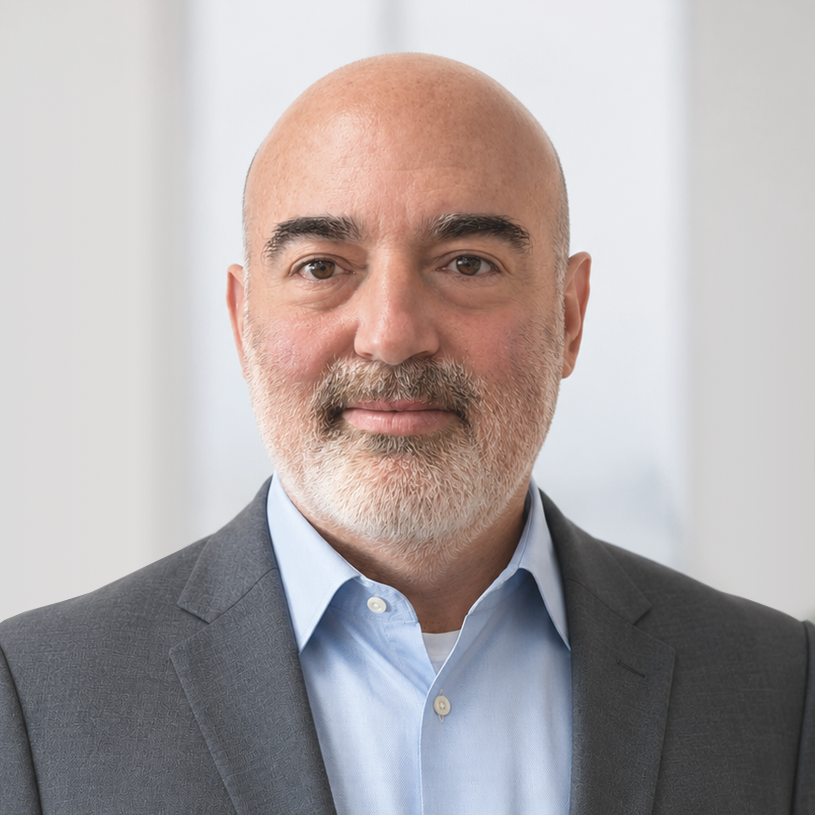 eric6 Professional headshot of bald man with gray beard wearing dark blazer and light blue shirt.